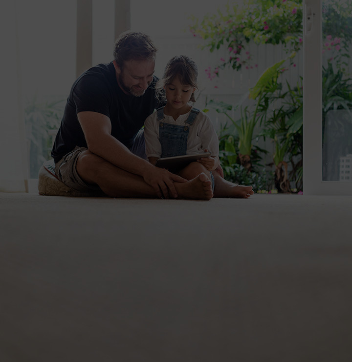 father sitting with his daughter and reading something