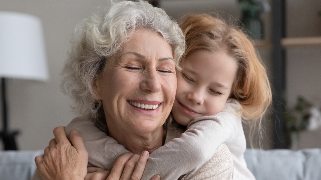 A little granddaughter hugs her grandmother