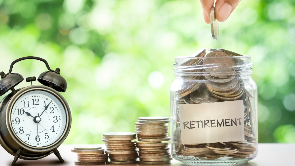 Glass jar with the inscription pension full of coins
