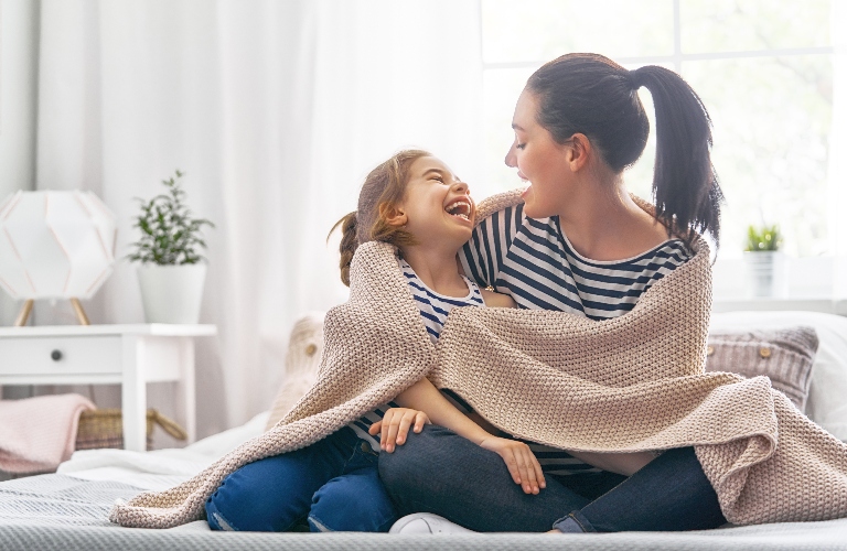 A woman hugs her daughter