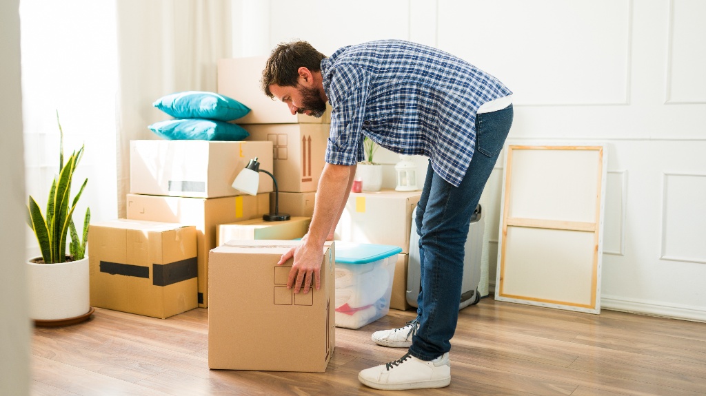 man lifts a heavy box during a move