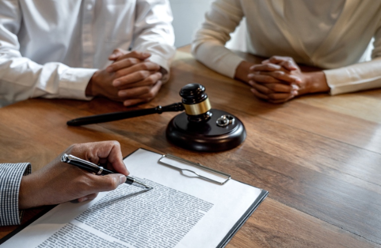 Divorce couple sitting arounf the table and consulting with a lawyer. Judges gavel on the table
