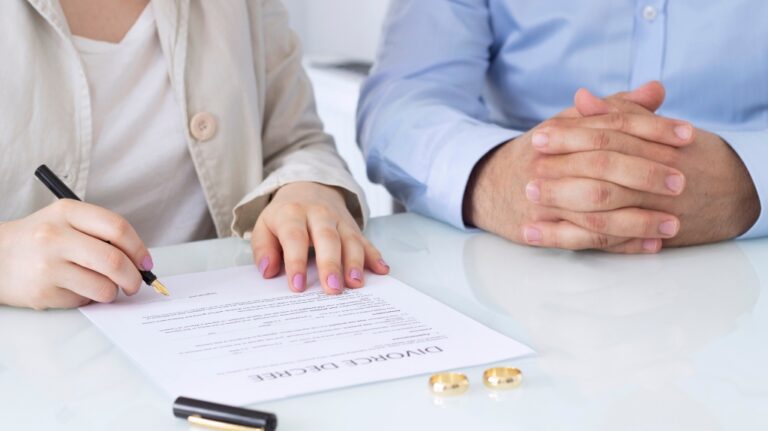 Hands of wife, husband signing decree of divorce