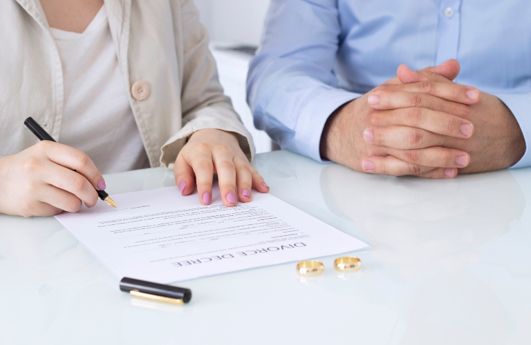 Hands of wife, husband signing decree of divorce